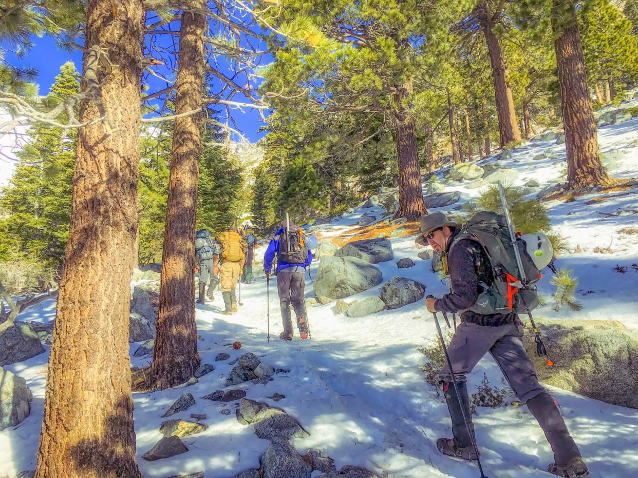 In this Feb. 6, 2016 photo, students of a mountaineering course head toward Mount Baldy just northeast of Los Angeles. They're carrying mountaineering gear including crampons, ice axes, poles and helmets.