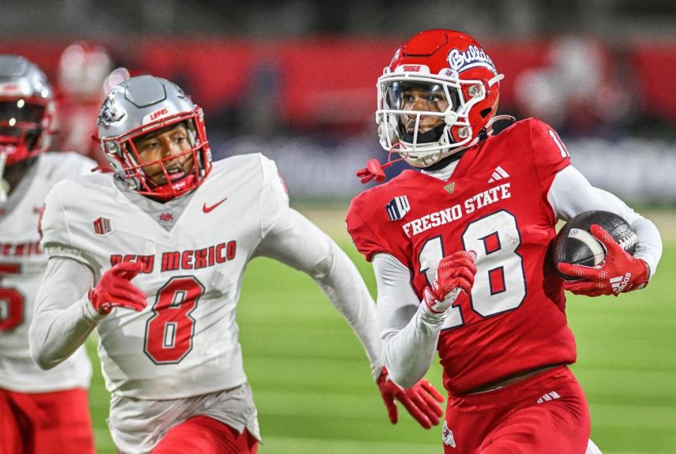 Fresno State wideout Jalen Moss, right, runs down the sideline with New Mexico’s Donte Martin in pursuit after a long gain on a pass from quarterback Logan Fife in the Bulldogs’ 25-17 loss on Saturday, Nov. 19, 2023.