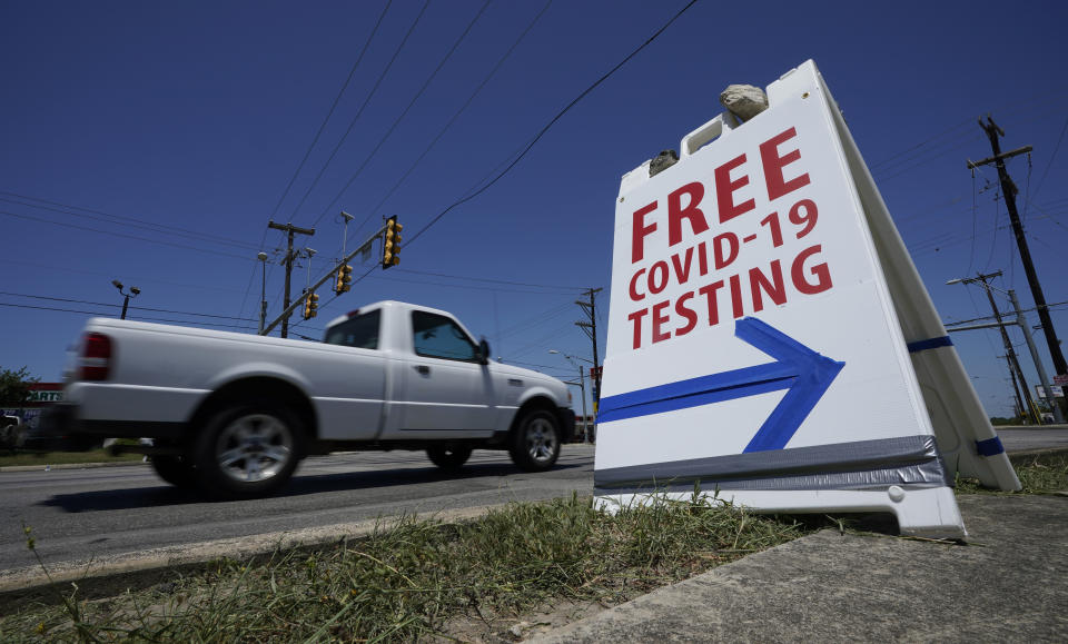 A truck passes a sign for free COVID-19 testing, Friday, Aug. 14, 2020, in San Antonio. Coronavirus testing in Texas has dropped significantly, mirroring nationwide trends, just as schools reopen and football teams charge ahead with plans to play. (AP Photo/Eric Gay)