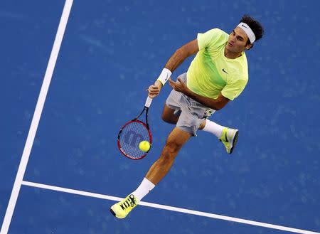 Roger Federer of Switzerland hits a return against Lu Yen-Hsun of Taiwan during their men's singles first round match at the Australian Open 2015 tennis tournament in Melbourne January 19, 2015. REUTERS/Carlos Barria