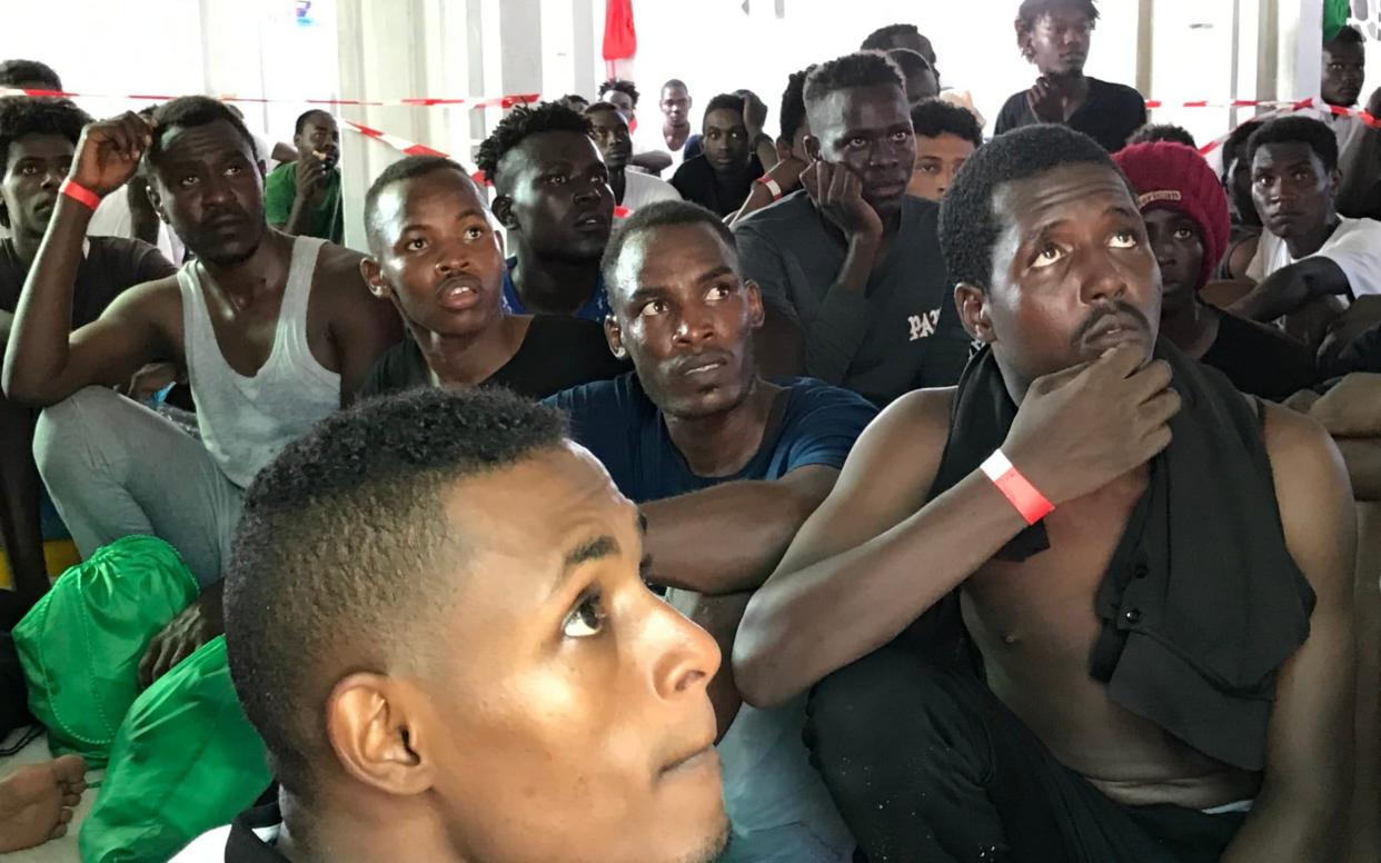 Rescued migrants rest on the desk of the 'Ocean Viking' rescue ship, operated by French NGOs SOS Mediterranee and Medecins sans Frontieres (MSF) - AFP