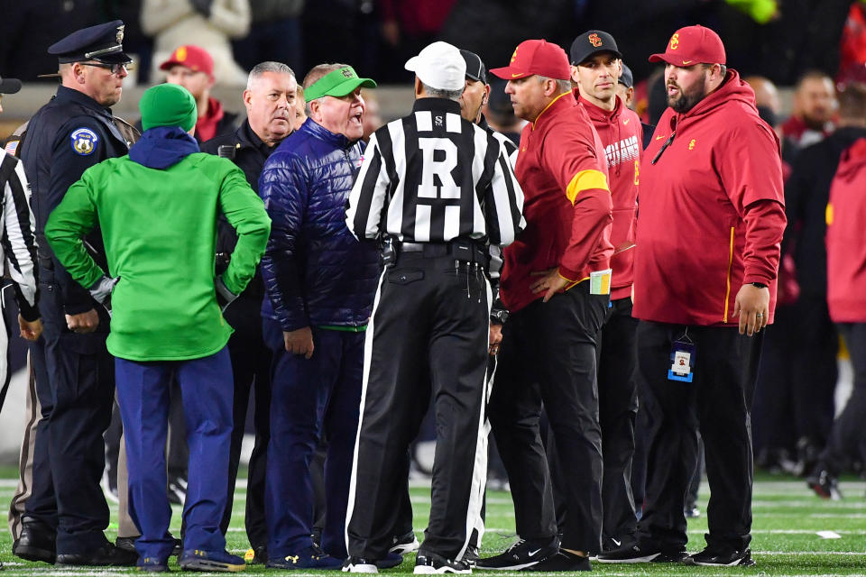 Oct 12, 2019; South Bend, IN, USA; Notre Dame Fighting Irish head coach Brian Kelly and USC Trojans head coach Clay Helton talk with referee Michael Mothershed after both teams were penalized for unsportsmanlike conduct after as the first half ended at Notre Dame Stadium. Mandatory Credit: Matt Cashore-USA TODAY Sports
