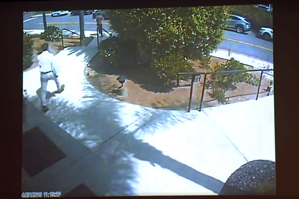 This April 27, 2019 photo from surveillance video at the Chabad of Poway, shown as evidence in the preliminary hearing of John T. Earnest, shows what authorities say is Earnest fleeing, in the street at top left, being pursued by Oscar Stewart, a combat veteran of Iraq and the first Gulf War, left center, after his rampage on the synagogue in Poway, Calif., in court in San Diego, Calif. on Thursday, Sept. 19, 2019. A woman was killed and three other people were wounded in the attack. Earnest has pleaded not guilty to murder, attempted murder and arson tied to a mosque fire. (Chabad of Poway/San Diego Superior Court via AP)