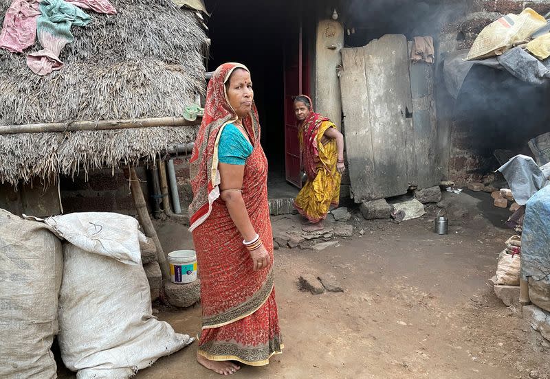 Tilottama Pradhan poses for a photograph outside her one-room house at Tarada village