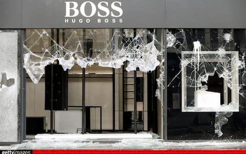  The vandalized facade of the Hugo Boss shop is seen after the 18th consecutive Saturday of demonstrations - Credit: Getty Images Europe