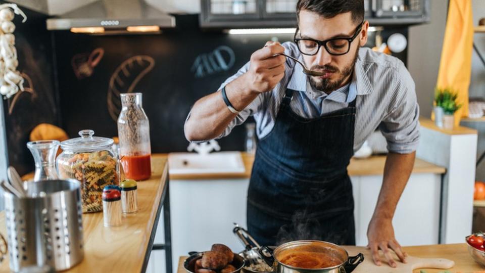 Hombre probando una sopa.