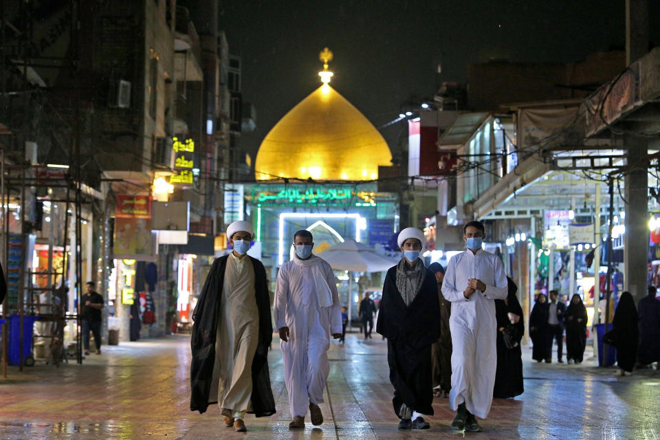 Shiite pilgrims walk outside the shrine of Imam Ali in Najaf, Iraq, Feb. 24, 2020 (AP Photo/Anmar Khalil)