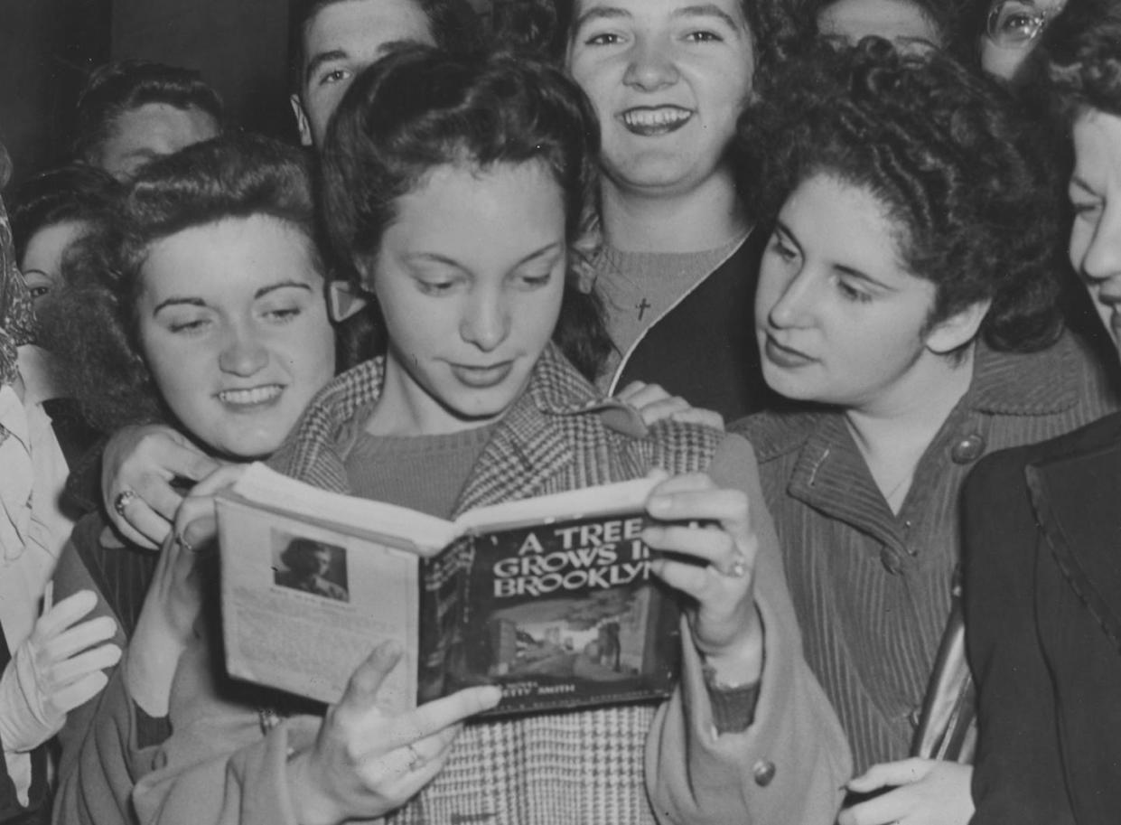 Betty Smith's novel sold millions of copies in the 1940s. <a href="https://www.gettyimages.com/detail/news-photo/group-of-young-women-smile-as-they-crowd-around-another-who-news-photo/119076541?adppopup=true" rel="nofollow noopener" target="_blank" data-ylk="slk:Weegee/International Center of Photography via Getty Images;elm:context_link;itc:0;sec:content-canvas" class="link ">Weegee/International Center of Photography via Getty Images</a>