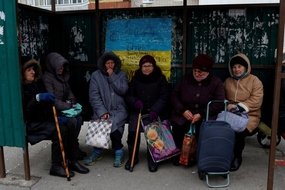 Women pause at a bus stop as they wait for the distribution of humanitarian aid after Russia's military retreat from Kherson, Ukraine November 22, 2022. REUTERS/Murad Sezer     TPX IMAGES OF THE DAY