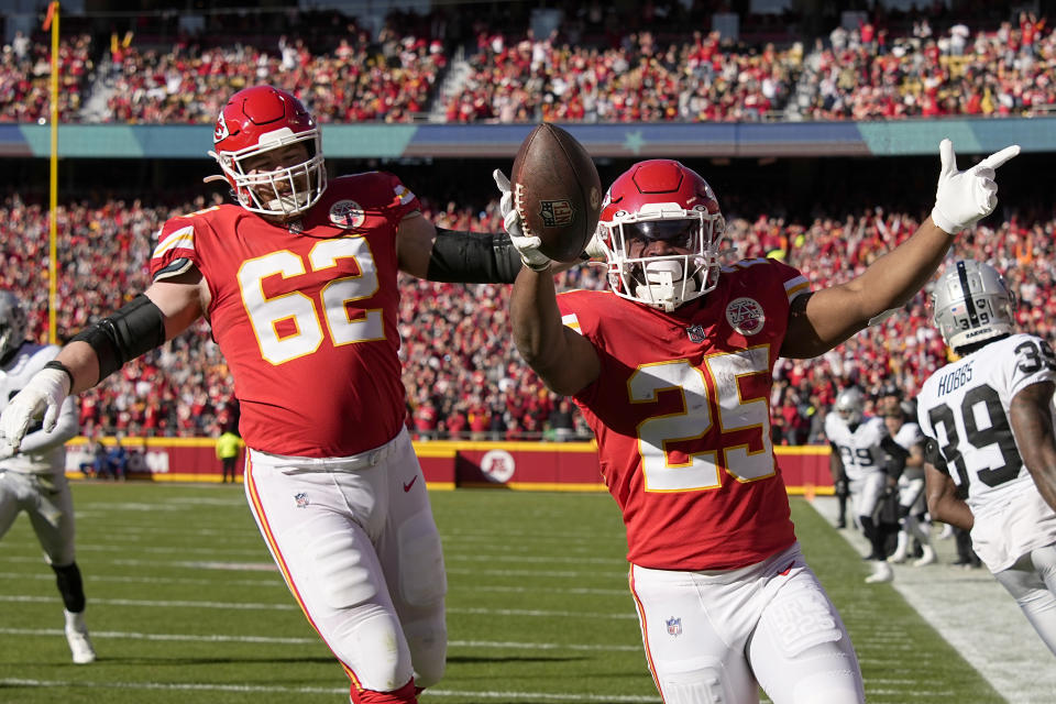 Kansas City Chiefs running back Clyde Edwards-Helaire (25) celebrates after scoring on a touchdown run as teammate Joe Thuney (62) watches during the first half of an NFL football game against the Las Vegas Raiders Sunday, Dec. 12, 2021, in Kansas City, Mo. (AP Photo/Charlie Riedel)