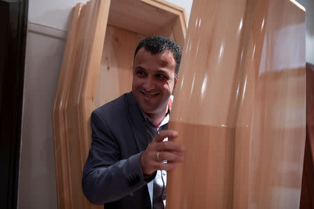 FILE PHOTO: Undertaker and candidate for town councillor at the municipality of Sykies, Konstantinos Baboulas, smiles as he poses inside a coffin at his family's funeral parlor in Thessaloniki, Greece, May 17, 2019. REUTERS/Alkis Konstantinidis