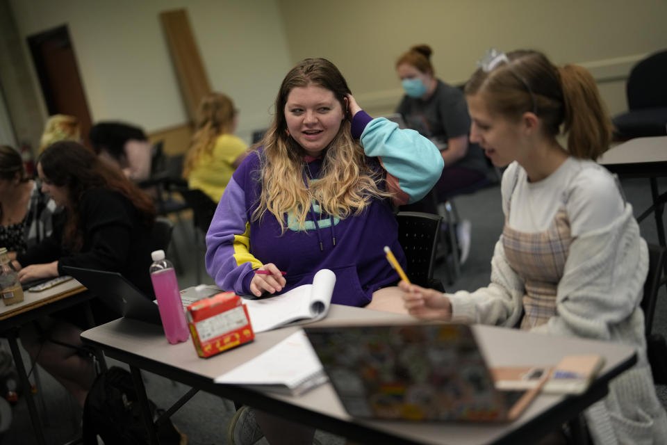 Students Camryn Robinson, left, and Adeline Harrell work together on an in-class project in their "Rhetoric of Walt Disney World" class at New College of Florida, Thursday, March 2, 2023, in Sarasota, Fla. The academic freedom that allows students to design individualized majors is mirrored by a student body that feels free to express itself, say students and faculty, who describe New College as a haven for brainy kids who are high-achieving and intellectually curious. (AP Photo/Rebecca Blackwell)