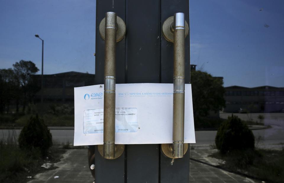 Una factura de agua en la puerta de una fábrica de ropa que cerró en 2013 en Salónica.