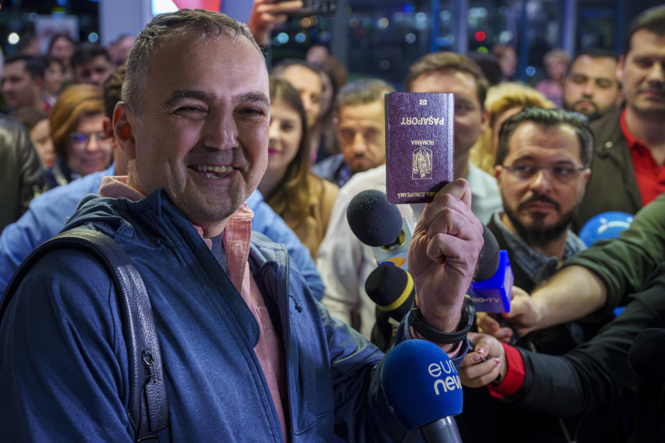 A passenger that arrived with a flight from Vienna shows his passport after being one of the first people to take advantage of Romania's entry in the Schengen Area without border checks by air and sea at the Henri Coanda International Airport in Otopeni, near Bucharest, Romania, Sunday, March 31, 2024. Romania and Bulgaria joined Europe's passport- and visa-free Schengen Area, applying only to travelers arriving by air and sea. (AP Photo/Andreea Alexandru)