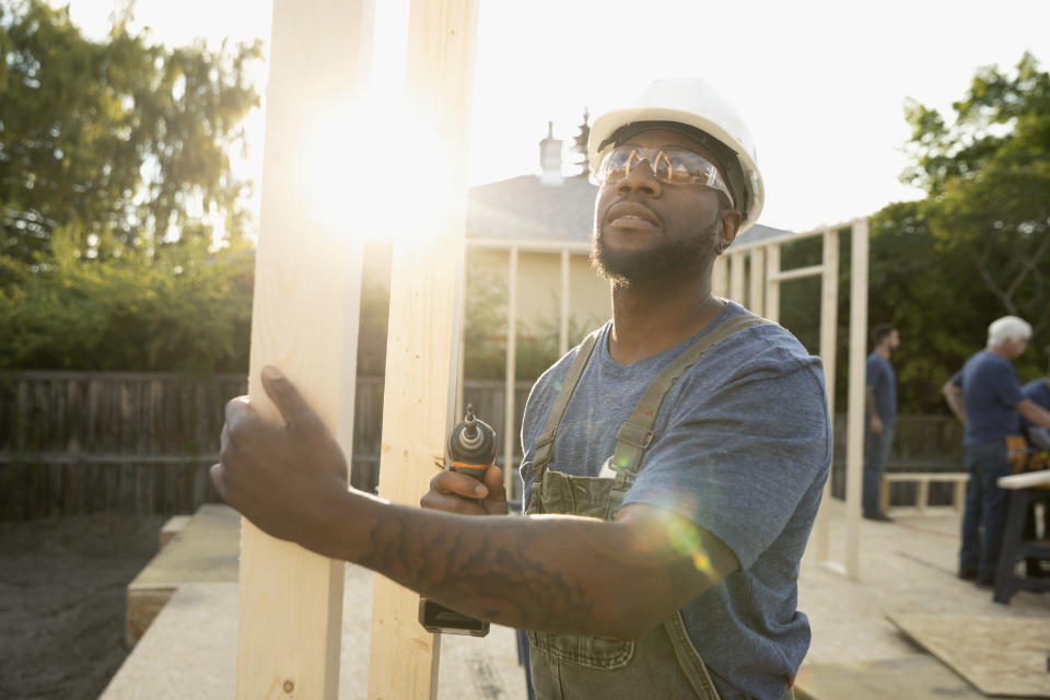 Man using power drill, working at construction site