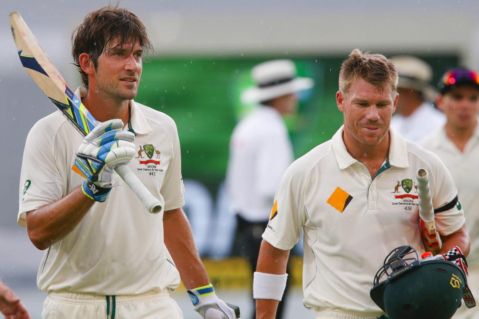 Australian batsman Joe Burns (pictured left) celebrates his maiden test century with opening partner David Warner (pictured right) as they walk off due to weather.