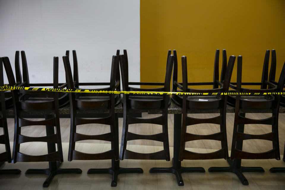 Dining chairs are stacked up on tables at a food court to prevent indoor dining due to the coronavirus pandemic in Los Angels, Wednesday, July 8, 2020. (AP Photo/Jae C. Hong)