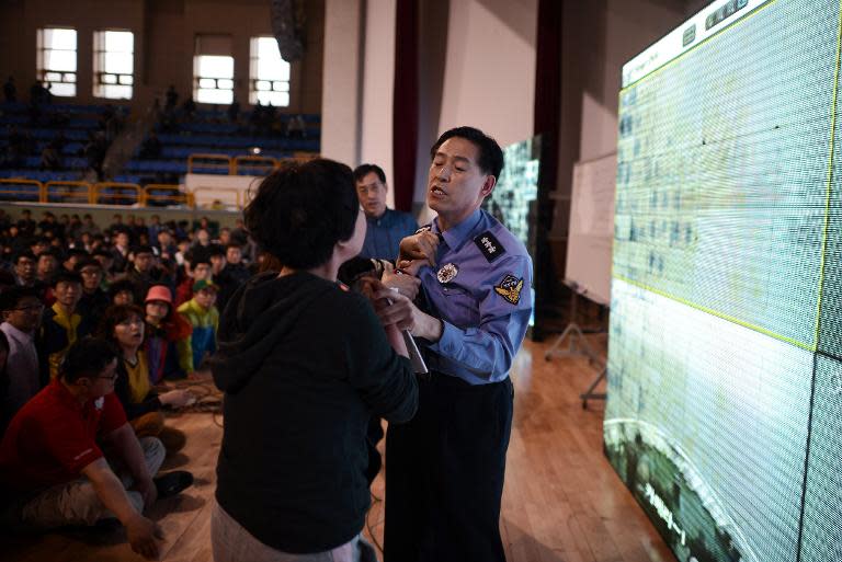 A woman confronts police chief Choi Sang Han (C) as relatives of missing passengers aboard a capsized ferry express frustration at conflicting reports of progress in the ongoing rescue and recovery operation, in Jindo on April 18, 2014