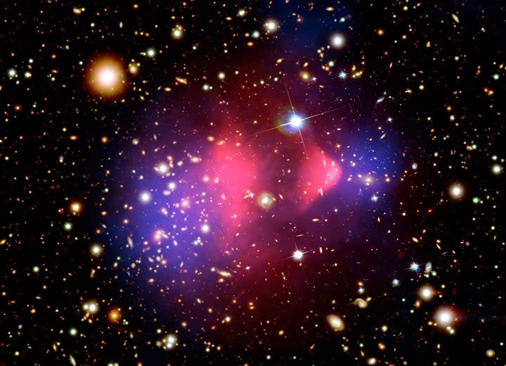This composite image shows the galaxy cluster 1E 0657-56, also known as the "bullet cluster." This cluster was formed after the collision of two large clusters of galaxies, the most energetic event known in the universe since the Big Bang. <em>Credit: X-ray: NASA/CXC/CfA/M.Markevitch et al.; Optical: NASA/STScI; Magellan/U.Arizona/D.Clowe et al.; Lensing Map: NASA/STScI; ESO WFI; Magellan/U.Arizona/D.Clowe et al.</em>