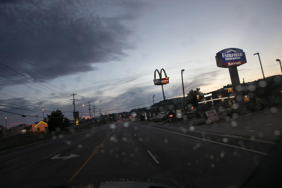 Signs are lit against the dusk sky in Athens, Ohio, on Wednesday, July 22, 2020. Appalachian Ohio has some of the poorest counties in the state, with child poverty rates higher than 30 percent. (AP Photo/Wong Maye-E)