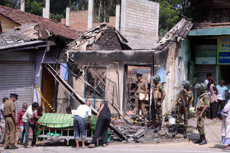 Sri Lanka's Special Task Force and Police officers stand guard near a burnt house after a clash between two communities in Digana, central district of Kandy, Sri Lanka March 6, 2018. REUTERS/Stringer