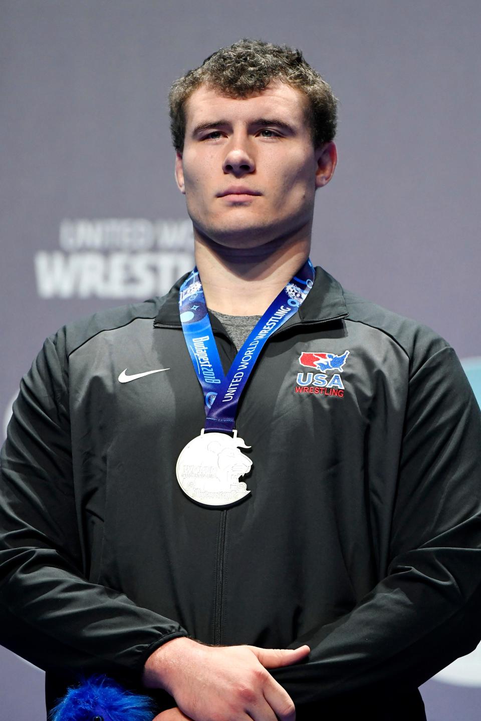 Fowlerville's Adam Coon stands on the podium with his silver medal at the Wrestling World Championships in Budapest, Hungary on Sunday, Oct. 28, 2018.