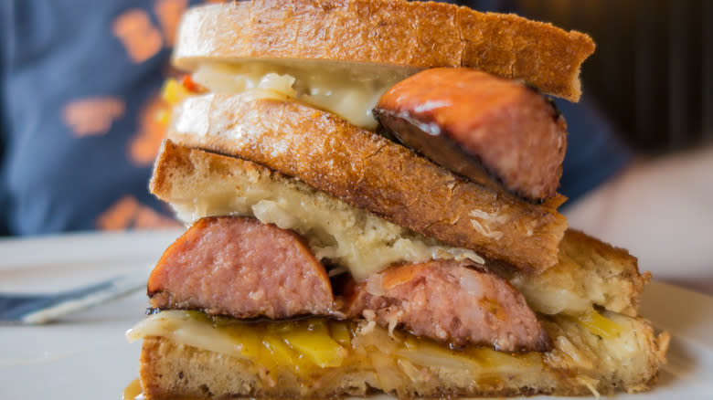 kielbasa sandwich with melted cheese and yellow mustard