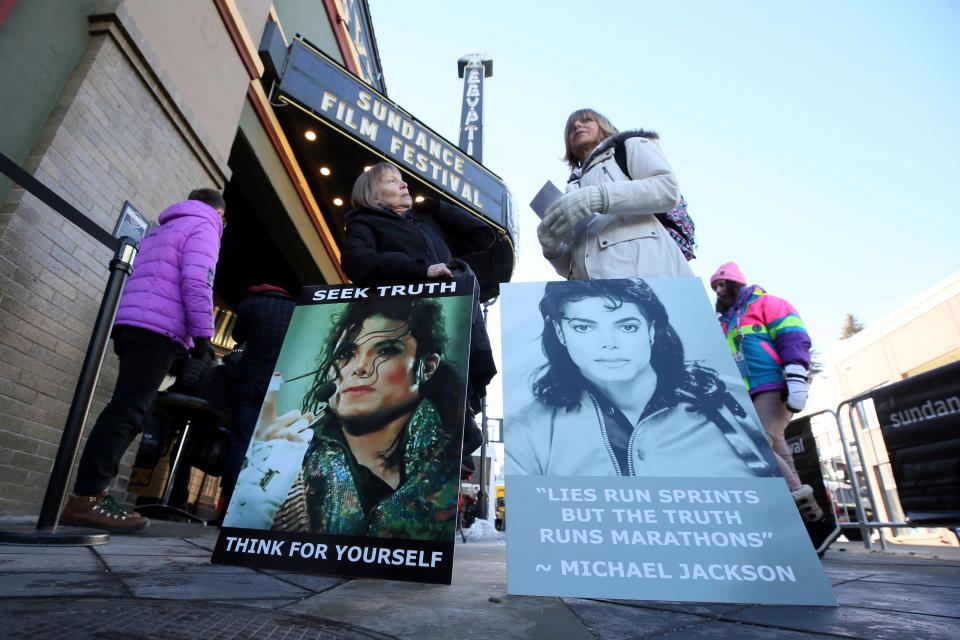 FILE- In this Jan. 25, 2019, file photo Brenda Jenkyns, left, and Catherine Van Tighem who drove from Calgary, Canada stand with signs outside of the premiere of the "Leaving Neverland" Michael Jackson documentary film at the Egyptian Theatre on Main Street during the 2019 Sundance Film Festival in Park City, Utah. Michael Jackson's family members said Monday, Jan. 28, that they are "furious" that two men who accuse him of sexually abusing them as boys have received renewed attention because of a new documentary about them. The family released a statement denouncing "Leaving Neverland," a documentary film featuring Jackson accusers Wade Robson and James Safechuck.  (Photo by Danny Moloshok/Invision/AP, File) ORG XMIT: NYJK704