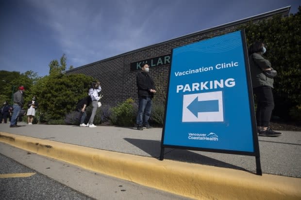 People are pictured lined up outside the Killarney Community Centre to receive their COVID-19 vaccination due to living in a ‘hot-spot’ neighbourhood in Vancouver, British Columbia on Monday, May 11, 2021. (Ben Nelms/CBC - image credit)