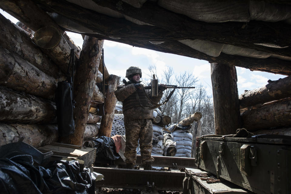 A Ukrainian solder check his weapon as he guards on the contact line in the village of Zolote 4, eastern Ukraine, Friday, March 29, 2019. Five years after a deadly separatist conflict in eastern Ukraine, the front line between government forces and Russia-backed separatists has become a de-facto border, cutting off a generation of first-time voters from Sunday's presidential election.(AP Photo/Evgeniy Maloletka)