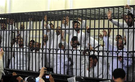 Supporters of the Muslim Brotherhood and ousted President Mohamed Mursi, standing trial on charges of violence that broke out in Alexandria last year, react after two fellow supporters were sentenced to death, in a court in Alexandria in this March 29, 2014 file photo. REUTERS/Al Youm Al Saabi Newspaper/Files