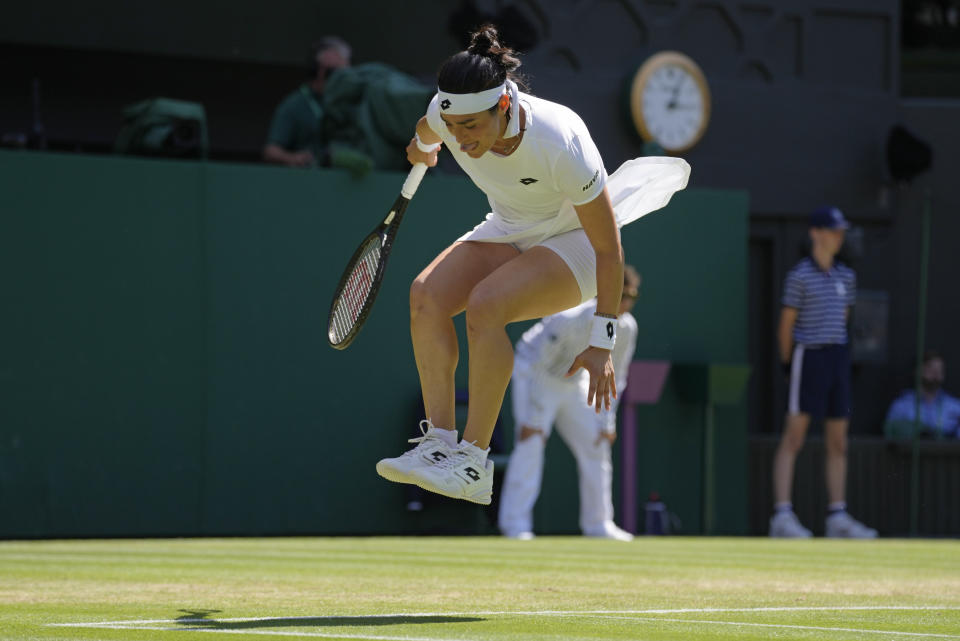 Tunisia's Ons Jabeur jumps in the air as she plays Germany's Tatjana Maria in a women's singles semifinal match on day eleven of the Wimbledon tennis championships in London, Thursday, July 7, 2022. (AP Photo/Kirsty Wigglesworth)