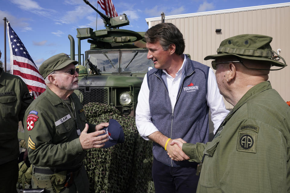 Republican gubernatorial candidate Glenn Youngkin, center, speaks with Army veterans Russell Claar, left, and Wayne Robinson after a rally in Fredericksburg, Va., Saturday, Oct. 30, 2021. Youngkin will face Democrat former Gov. Terry McAuliffe in the November election. (AP Photo/Steve Helber)