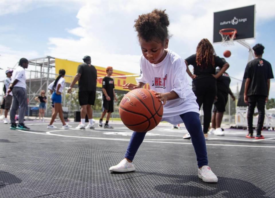 A child dribbles a basketball during a youth basketball clinic hosted by Rolling Loud and the Miami HEAT at the Rolling Loud basketball court outside Hard Rock Stadium in Miami Gardens, Fla., on Wednesday, July 19, 2023.