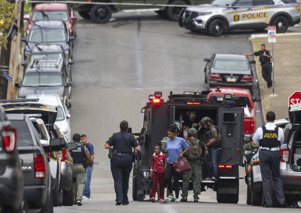 Residents are safely removed from the street during a standoff with a gunman in the Garfield neighborhood of Pittsburgh on Wednesday, Aug. 23, 2023. (Benjamin B. Braun/Pittsburgh Post-Gazette via AP)