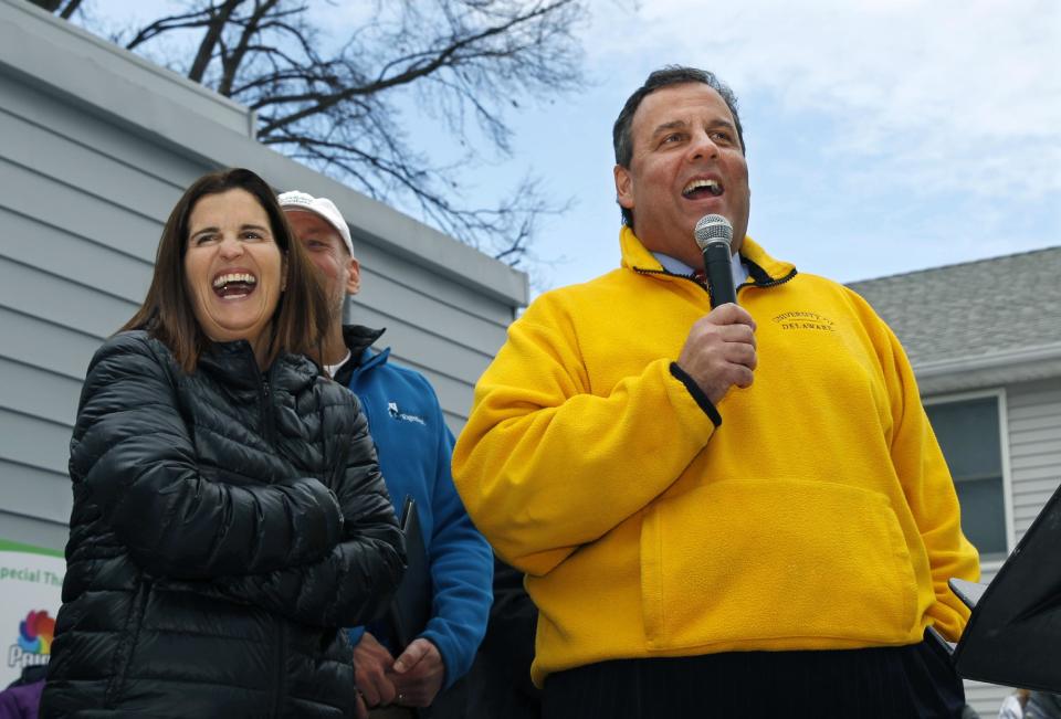 First lady Mary Pat Christie, left, laughs as New Jersey Gov. Chris Christie greet volunteers and family and neighbors outside a renovated home that was heavily damaged by Superstorm Sandy in a town near MetLife Stadium, where Sunday's Super Bowl game is to be played, Friday, Jan. 31, 2014, in Moonachie, N.J. The Christies moved some furniture to help a family move back into a home rebuilt after Superstorm Sandy. The volunteer event Friday was part of the NFL-sanctioned Rebuilding Together event. (AP Photo/Mel Evans)