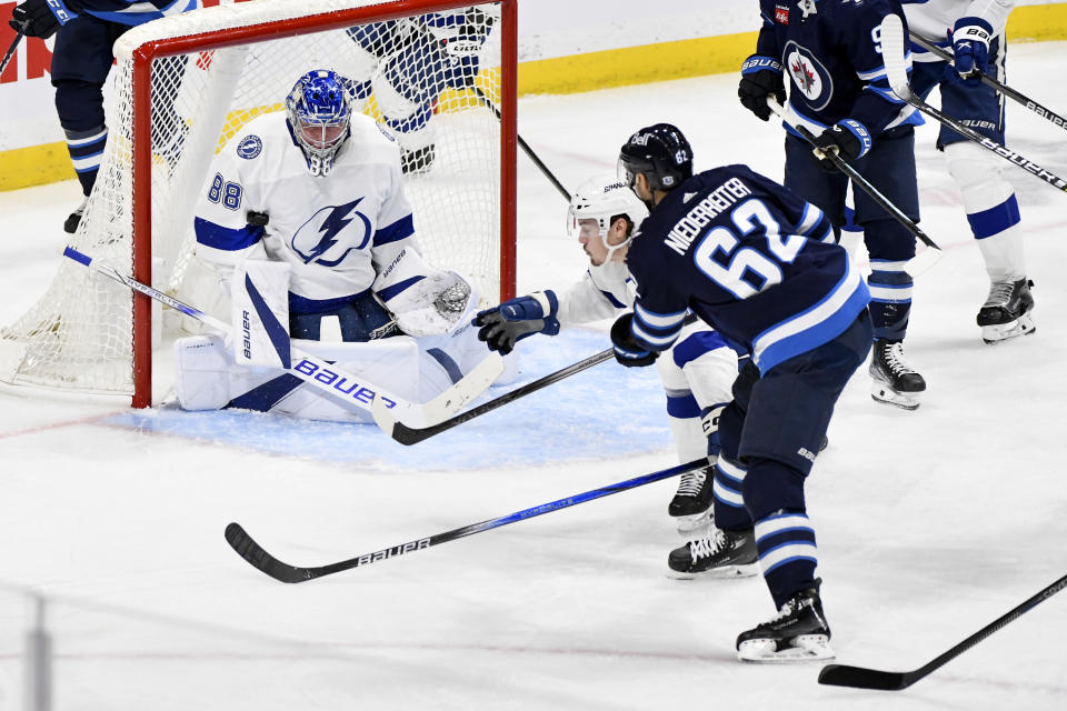 Tampa Bay Lightning goaltender Andrei Vasilevskiy (88) makes a save on Winnipeg Jets' Nino Niederreiter (62) during the third period of an NHL hockey game Tuesday, Jan. 2, 2024, in Winnipeg, Manitoba. (Fred Greenslade/The Canadian Press via AP)