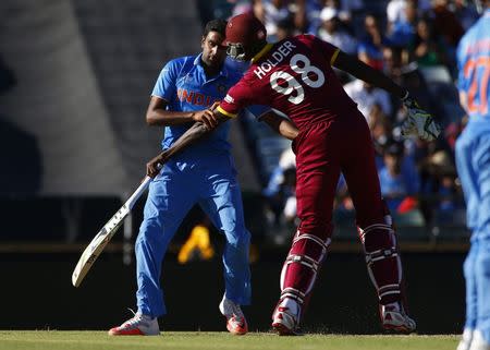 India's bowler Ravichandran Ashwin (L) collides with West Indies captain Jason Holder during their Cricket World Cup match in Perth, March 6, 2015. REUTERS/David Gray