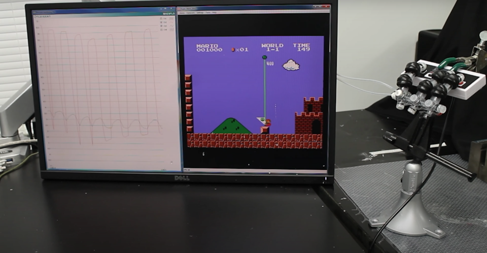 A soft robotic hand plays Super Mario Bros. based on inputs from a computer program.