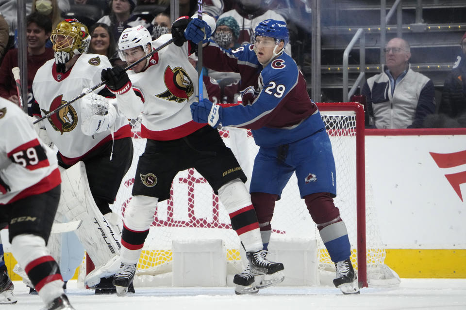 Ottawa Senators defenseman Travis Hamonic jostles for position in front of the net with Colorado Avalanche center Nathan MacKinnon, right, during the second period of an NHL hockey game Thursday, Dec. 21, 2023, in Denver. (AP Photo/David Zalubowski)