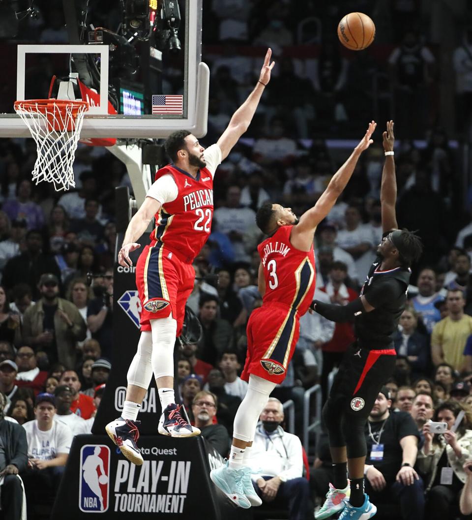 Clippers guard Reggie Jackson lofts a shot over Pelicans forward Larry Nance Jr. and guard CJ McCollum.