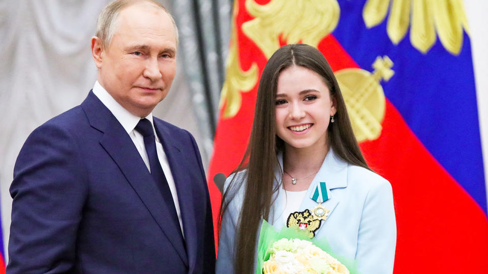 This photo shows Russian president Vladimir Putin standing next to teen figure skater Kamila Valieva.