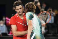 Stefanos Tsitsipas, right, of Greece is congratulated by Taylor Fritz of the U.S. following their fourth round match at the Australian Open tennis championships in Melbourne, Australia, early Tuesday, Jan. 25, 2022. (AP Photo/Simon Baker)