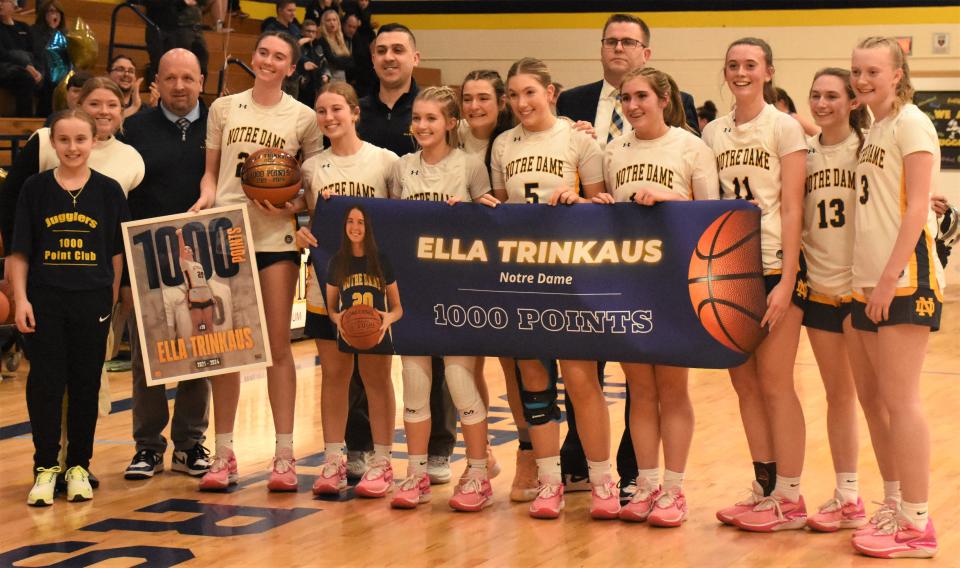 Sophomore Ella Trinkaus holds the ball to the left of her Notre Dame teammates and poses with the Jugglers after scoing the 1,000th point of her varsity career Feb. 13.