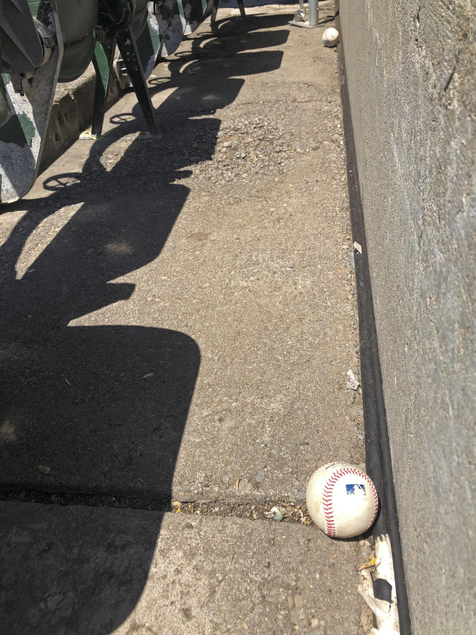 Baseballs fouled off by players are seen stopped at the bottom row of the Oakland Coliseum after rolling down through empty stands during the baseball game between the Los Angeles Angels and the Oakland Athletics on Monday, July 27, 2020, in Oakland, Calif. (AP Photo/Ben Margot)