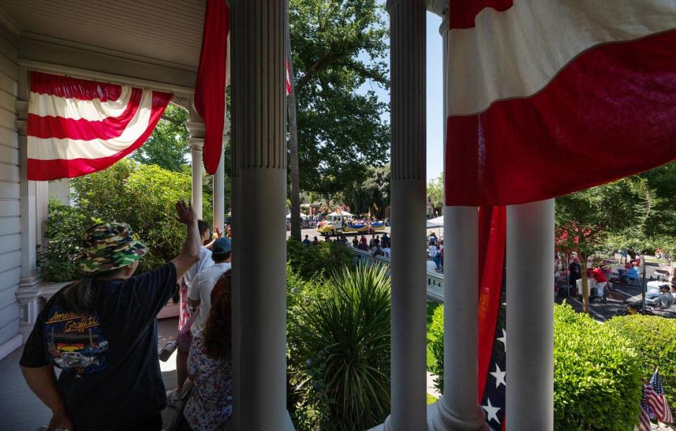 People watch the Independence Day Parade from the McHenry Mansion porch in Modesto, Calif., Tuesday, July 4, 2023. Andy Alfaro/aalfaro@modbee.com