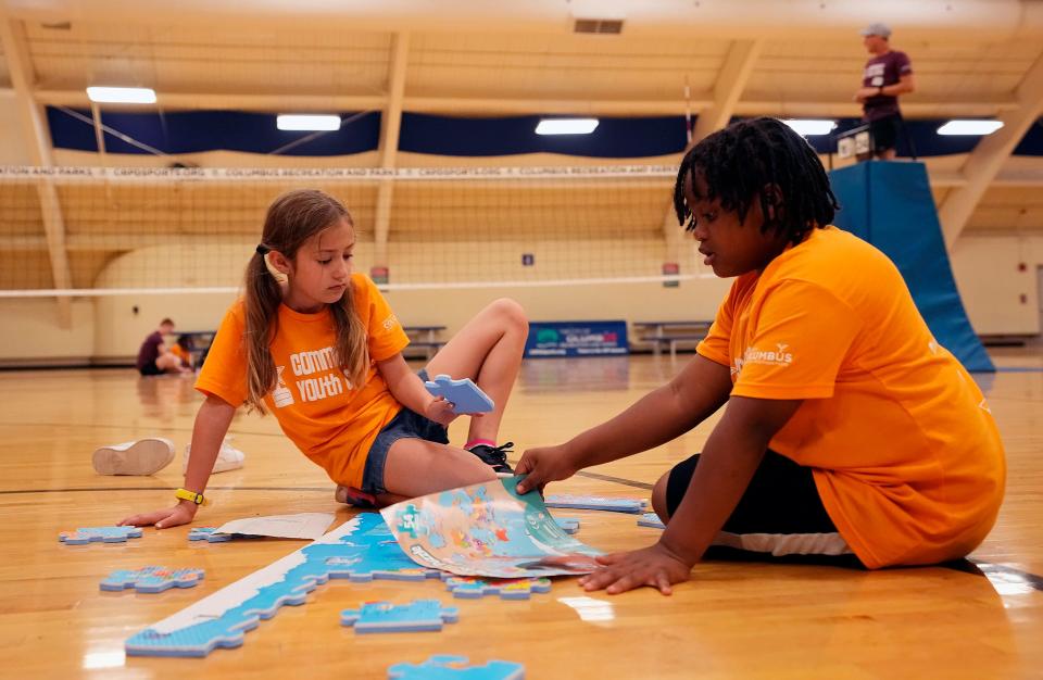 Penelope Kramer, left, and Jayden Jones, right, put together a puzzle during the Greater Columbus Sports Commission's Community Youth Camp on June 7.