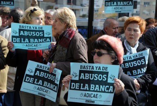 Protesters hold banners reading "Enough of banking abuses" outside the headquarters of Bankia in Madrid. The borrowing rate on Spain's 10-year bonds shot to a danger level of 6.703 percent -- unsustainable over the longer term -- as Spain battled to avoid becoming the next nation to fall to the eurozone crisis