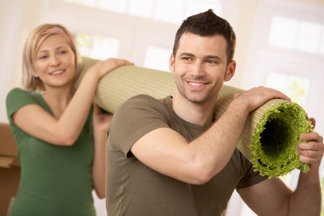 happy couple carrying carpet...