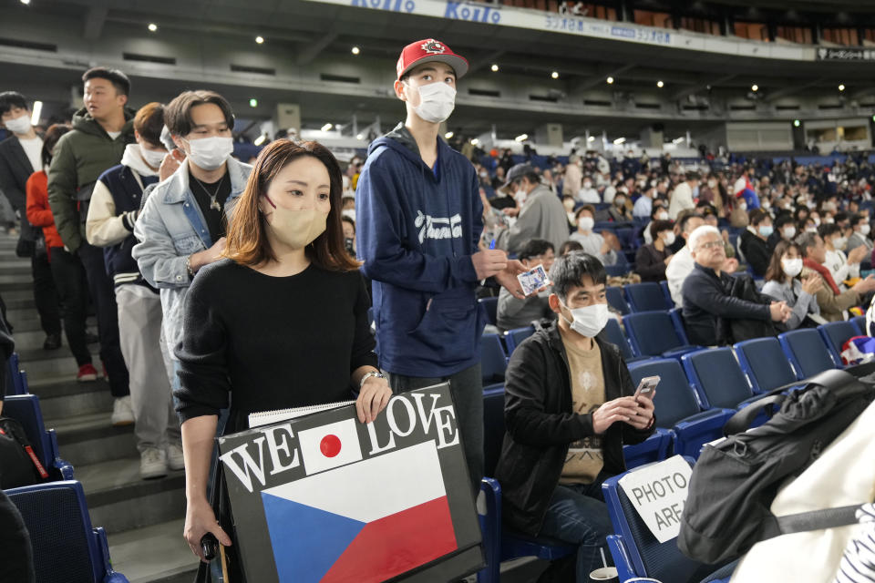 Spectators wait for a Pool B game between Australia and the Czech Republic at the World Baseball Classic at Tokyo Dome in Tokyo, Japan, Monday, March 13, 2023. The Japanese government relaxed its mask-wearing guidelines on Monday, but the vast majority of fans at the Tokyo Dome watching the World Baseball Classic still wore them. (AP Photo/Shuji Kajiyama)